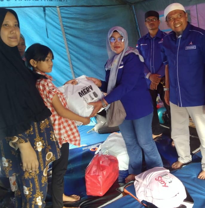 Rosmeri didampingi Tua Demokrat Fakhrudi, saat serahkan bantuan.